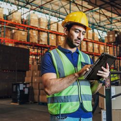 Magazijnmedewerker gebruikt een mobiele tablet in een logistiek magazijn